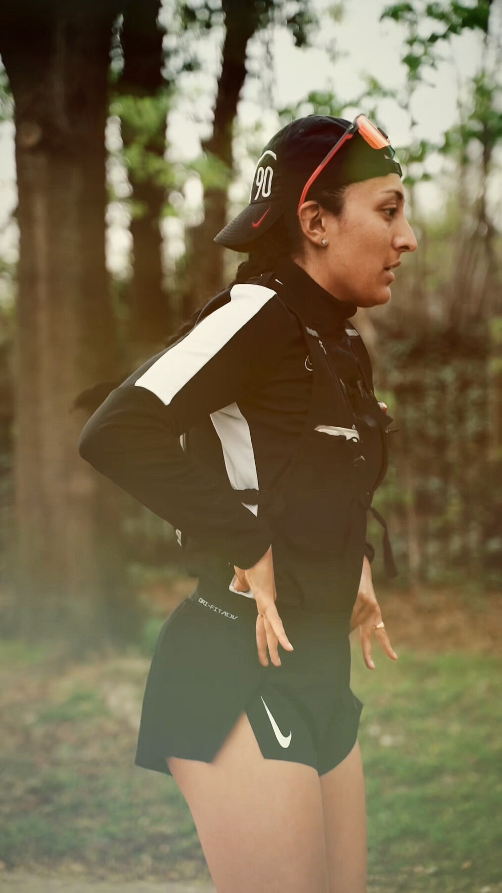 Vnisha on a trail run in cap and sunglasses